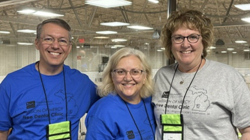 Three smiling dental volunteers at Michigan Dental Association Mission of Mercy Free Dental Clinic